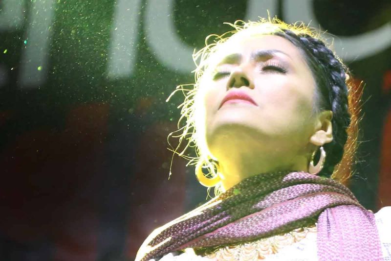 Rocío Vega en pleno concierto en vivo ojos cerrados mientras le da la luz en la cara
